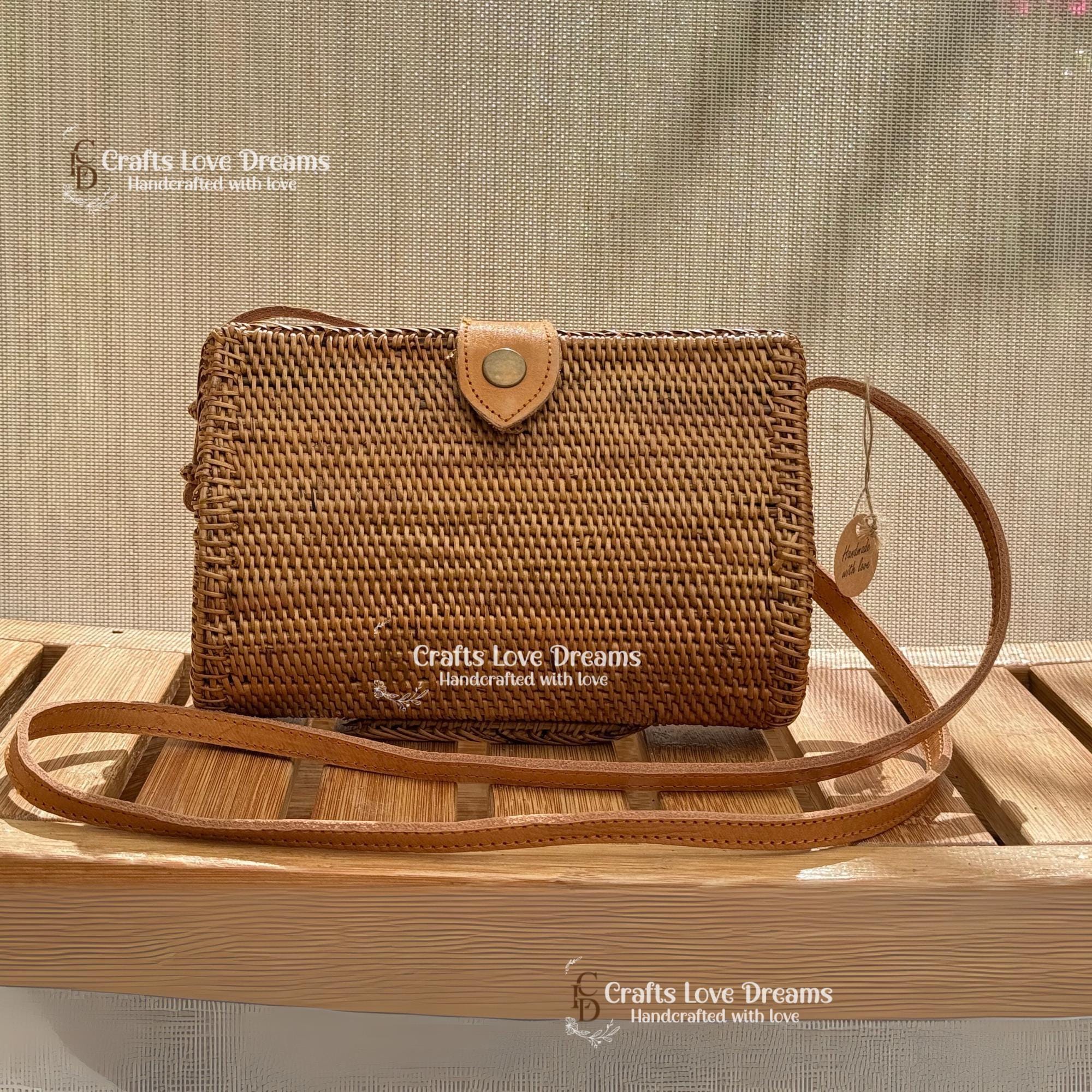 A brown woven handbag with a leather strap, displayed on a wooden surface.