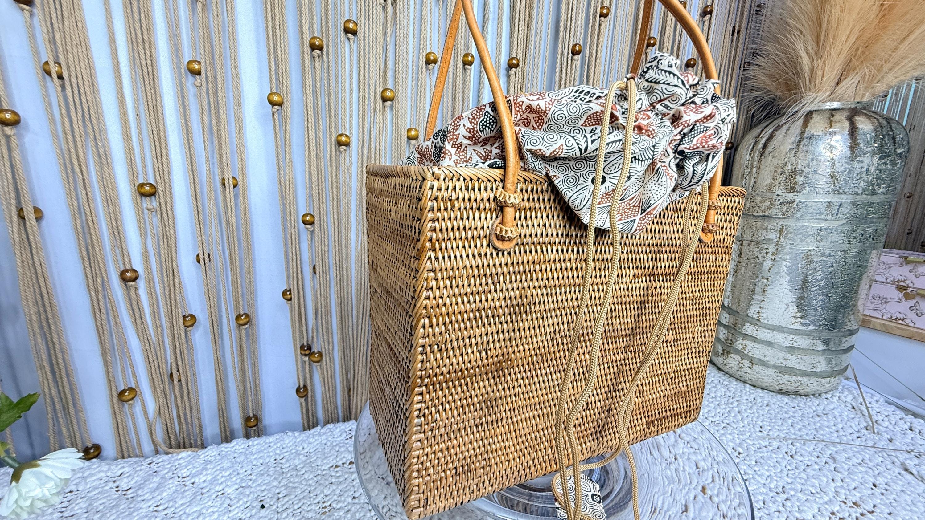 Handwoven rattan square tote with the batik drawstring liner closed, shown with the Crafts Love Dreams hang tag