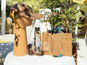 Rattan square totes with batik liners displayed outdoors on a table with a straw hat