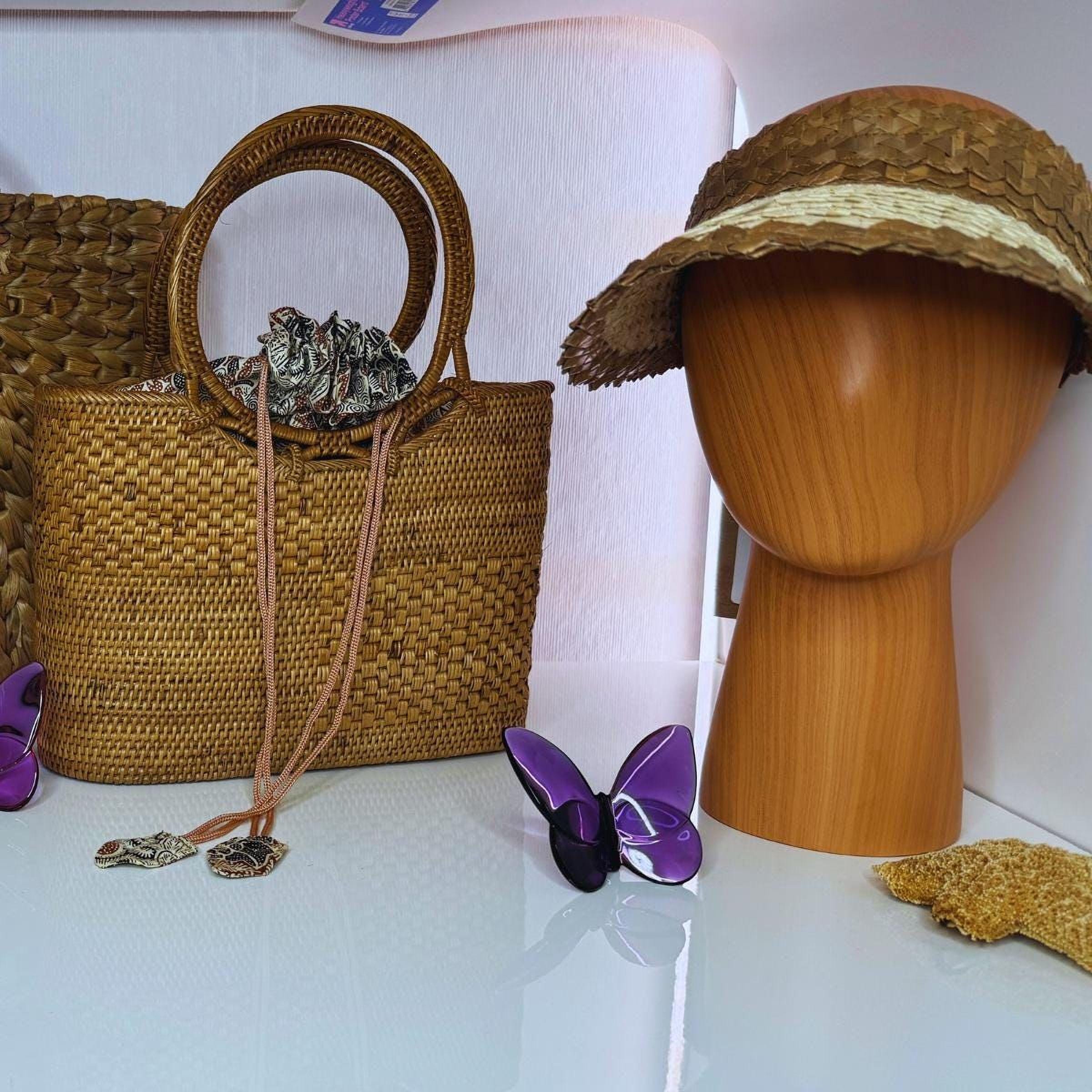 a woven handbag, a wooden headband, a purple butterfly figurine, and a small wooden object on a white surface.