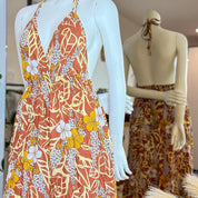 two mannequins wearing dresses with floral patterns in warm colors.