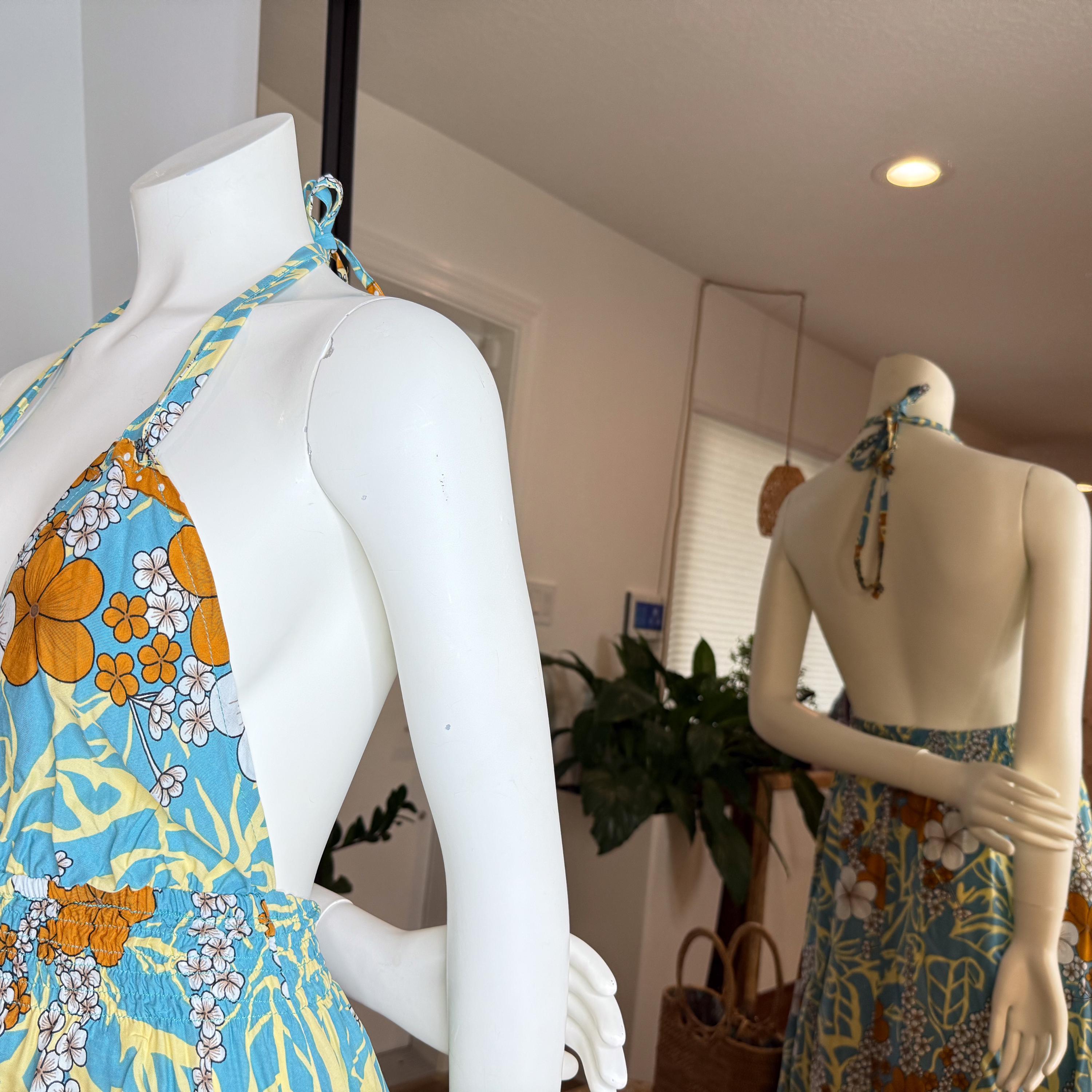 two mannequins wearing colorful floral dresses, with one mannequin in the foreground and the other in the background.