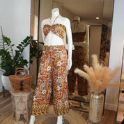 A mannequin wearing a colorful, patterned top and pants, displayed in a clothing store.