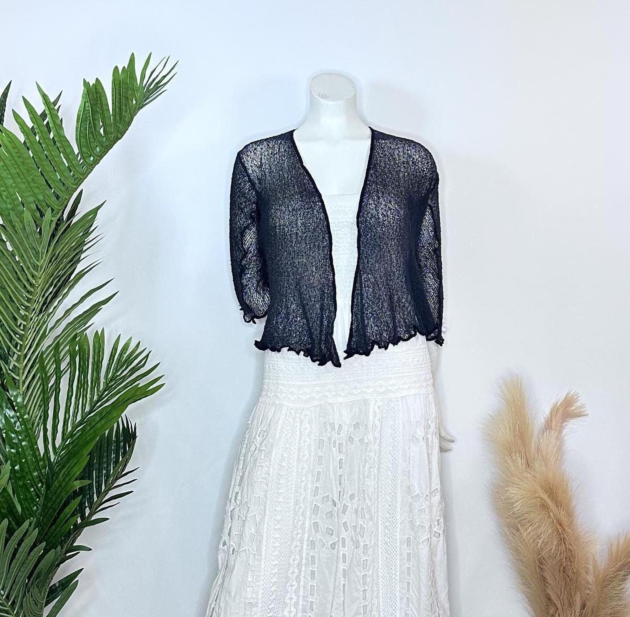 A mannequin wearing a black lace top and a white lace skirt, with a black shawl draped over the top.