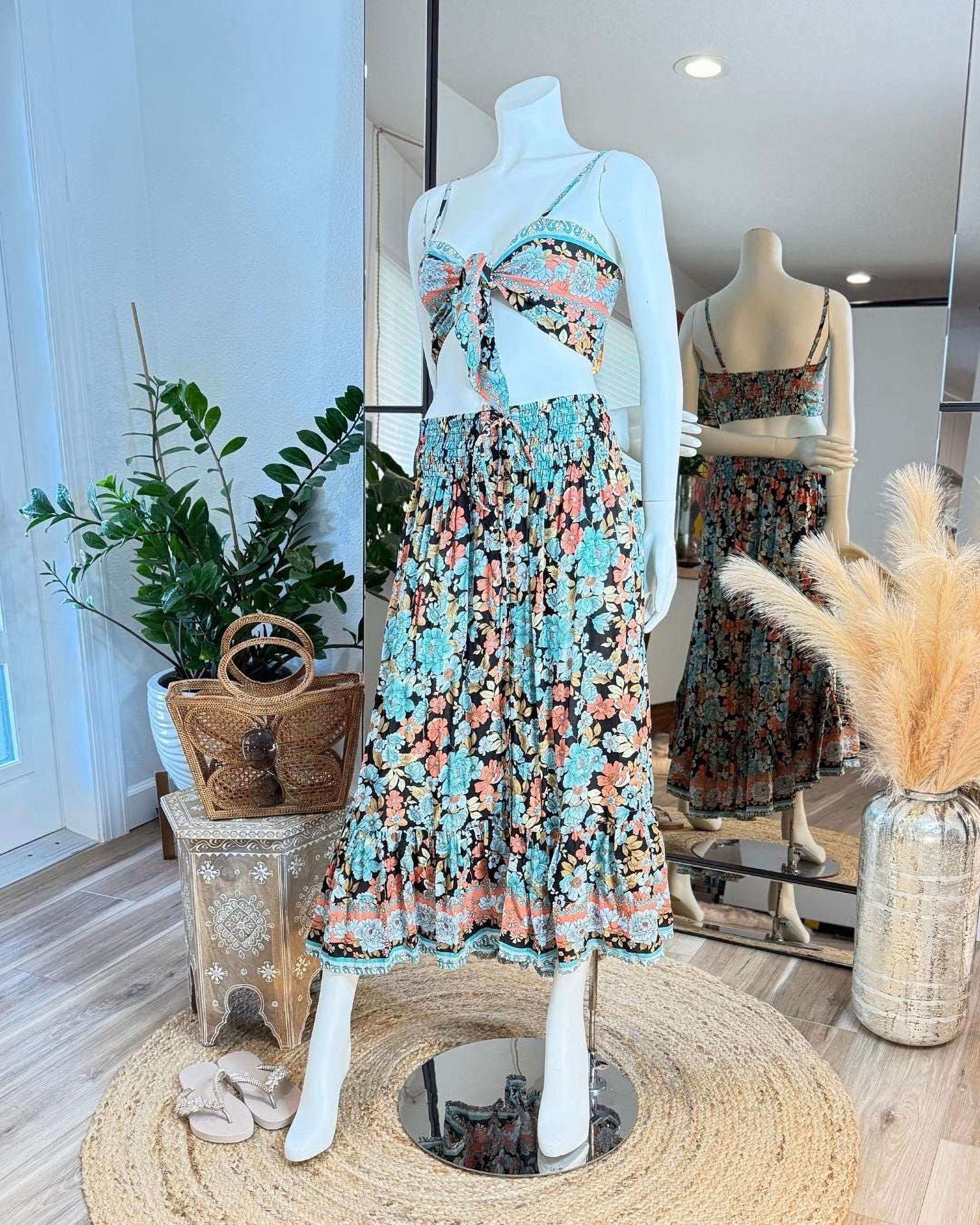 A mannequin wearing a colorful floral print dress and skirt, displayed in a clothing store.