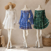 Three mannequins wearing off-the-shoulder dresses in different colors - white, blue, and green - stand against a beige wall.