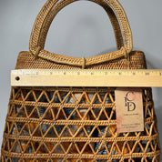 A woven handbag with a wicker pattern and a wooden ruler placed over it, indicating the size of the bag.