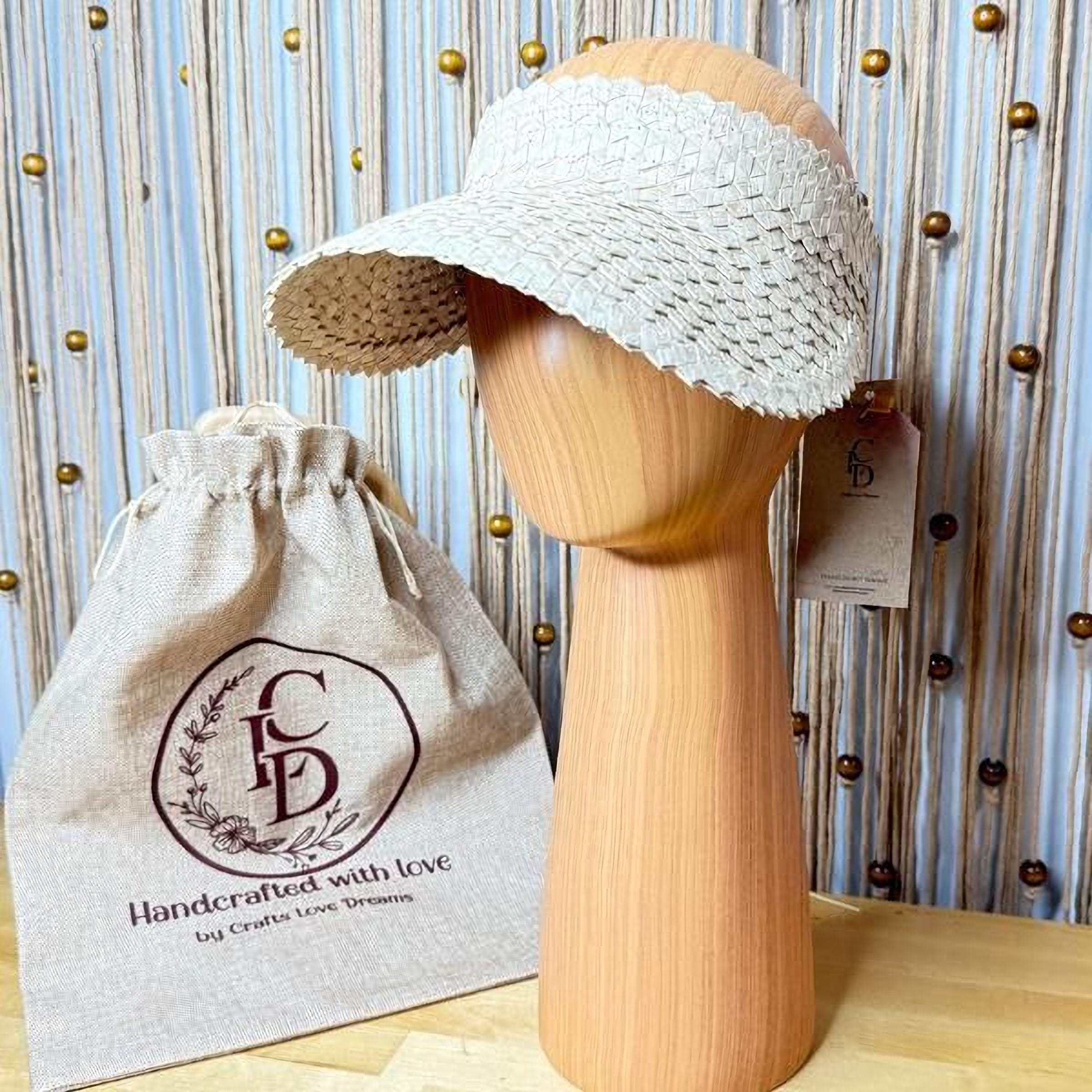 a wooden headband and a beige drawstring bag with a logo, placed on a wooden surface against a blue background with gold dots.