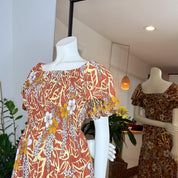 two mannequins wearing dresses with floral patterns, one in the foreground and one in the background.