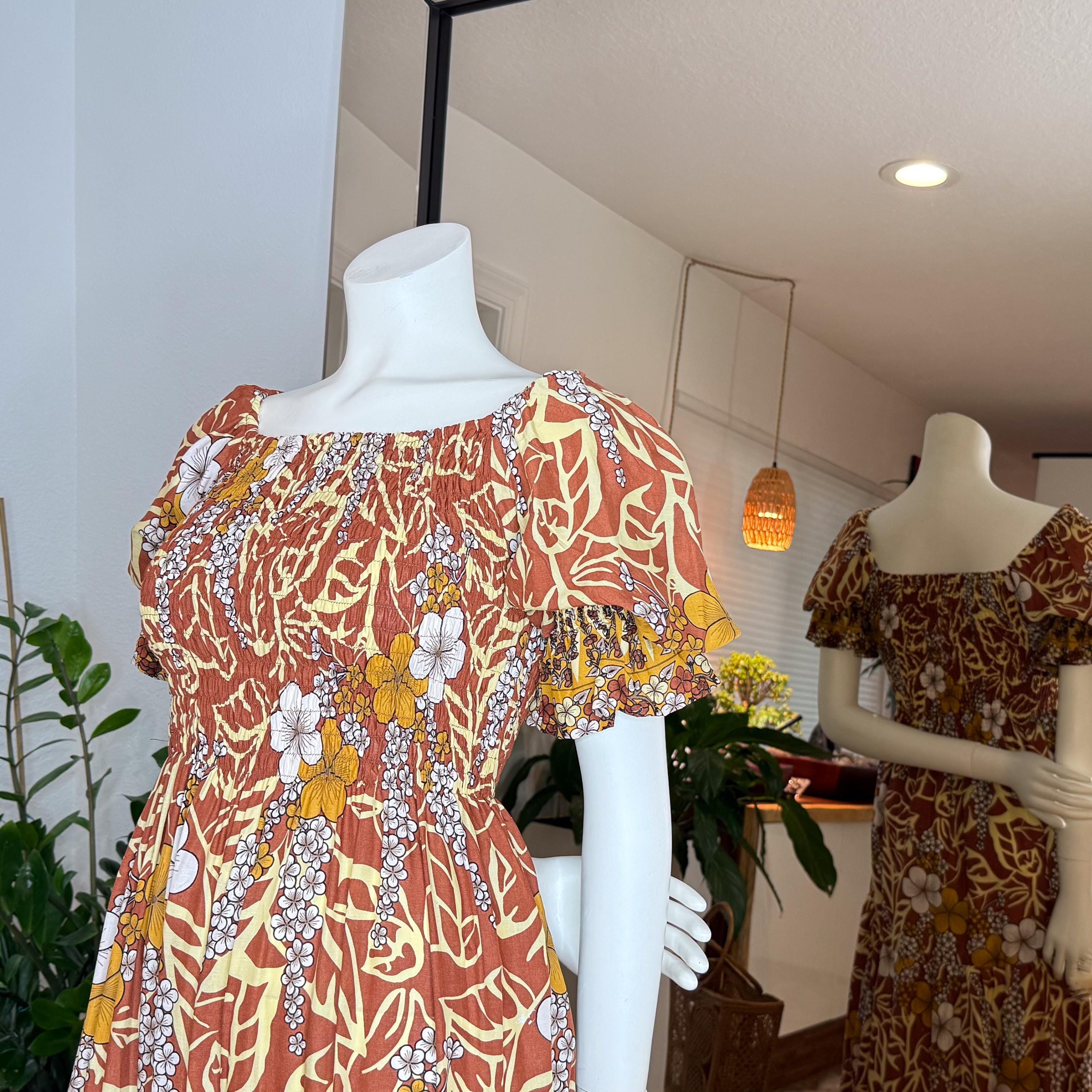 two mannequins wearing dresses with floral patterns, one in the foreground and one in the background.