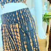 A mannequin wearing a tie-dye skirt with a pattern of blue and orange dots.