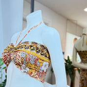 A mannequin wearing a colorful, patterned top with a floral design.