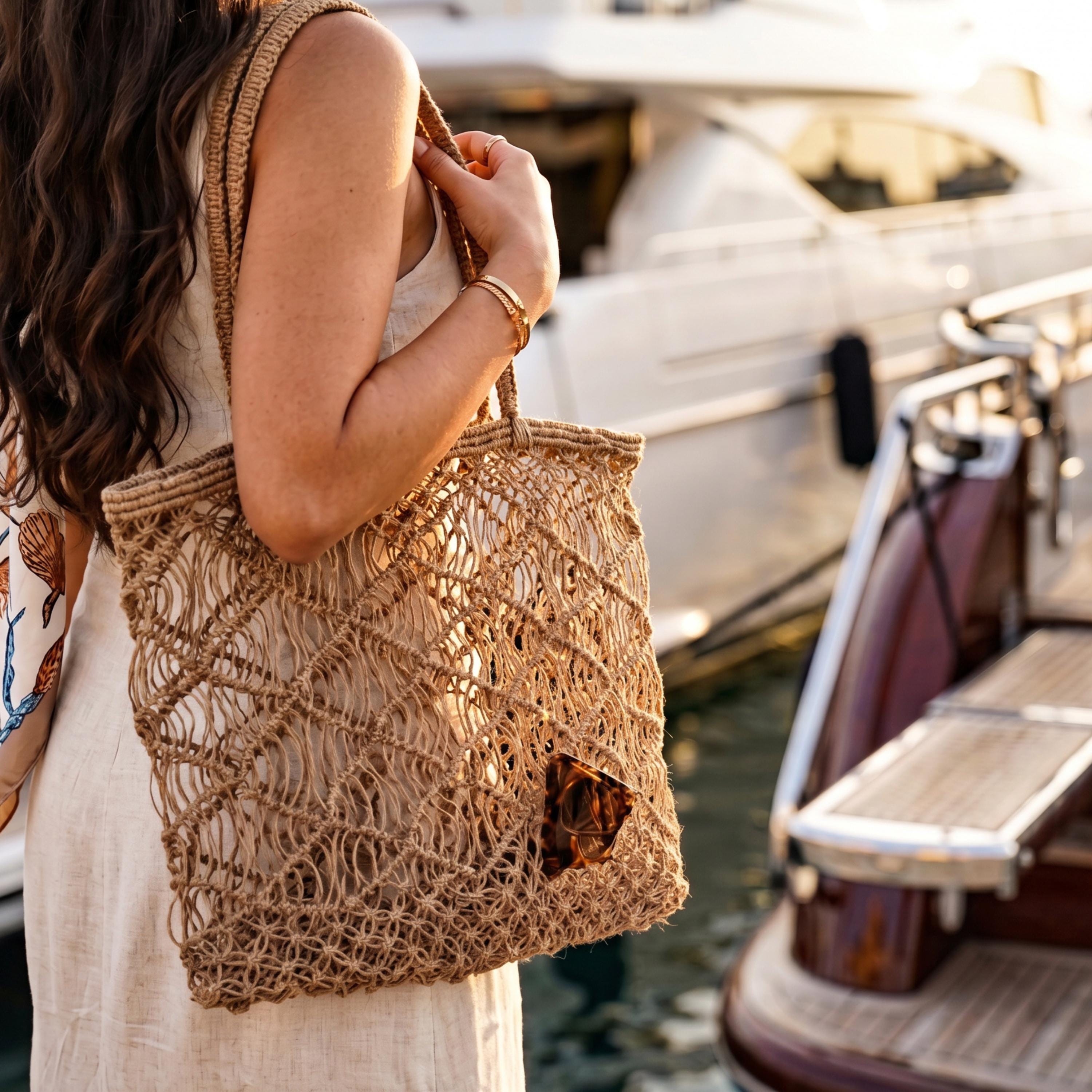 A woman in a white dress carrying a woven bag stands near a boat on a dock.