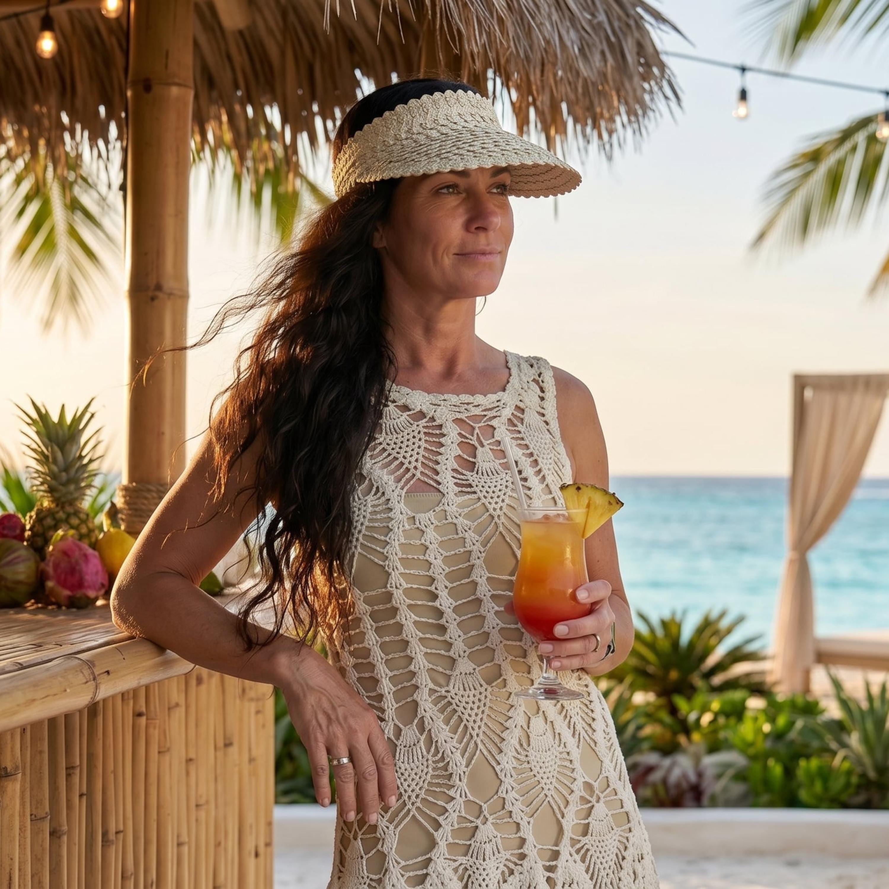 A woman in a white lace dress and a straw hat stands near a tropical bar, holding a drink and looking out at the ocean.