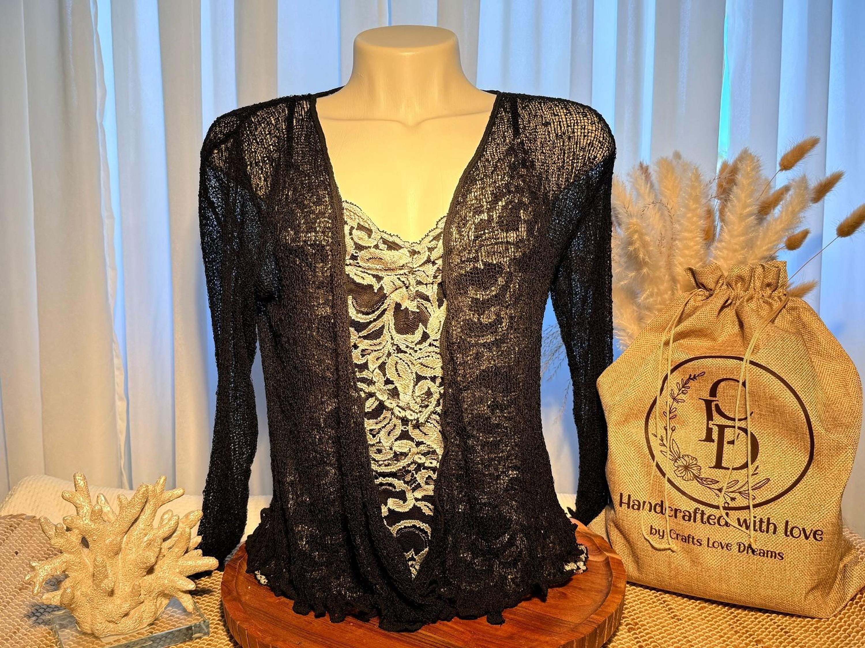 A mannequin wearing a black lace top with a floral pattern, placed on a wooden stand next to a burlap sack with the text "Handcrafted with love by Crafts Love Dreams".