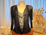A mannequin wearing a black lace top with a floral pattern, placed on a wooden stand next to a burlap sack with the text "Handcrafted with love by Crafts Love Dreams".