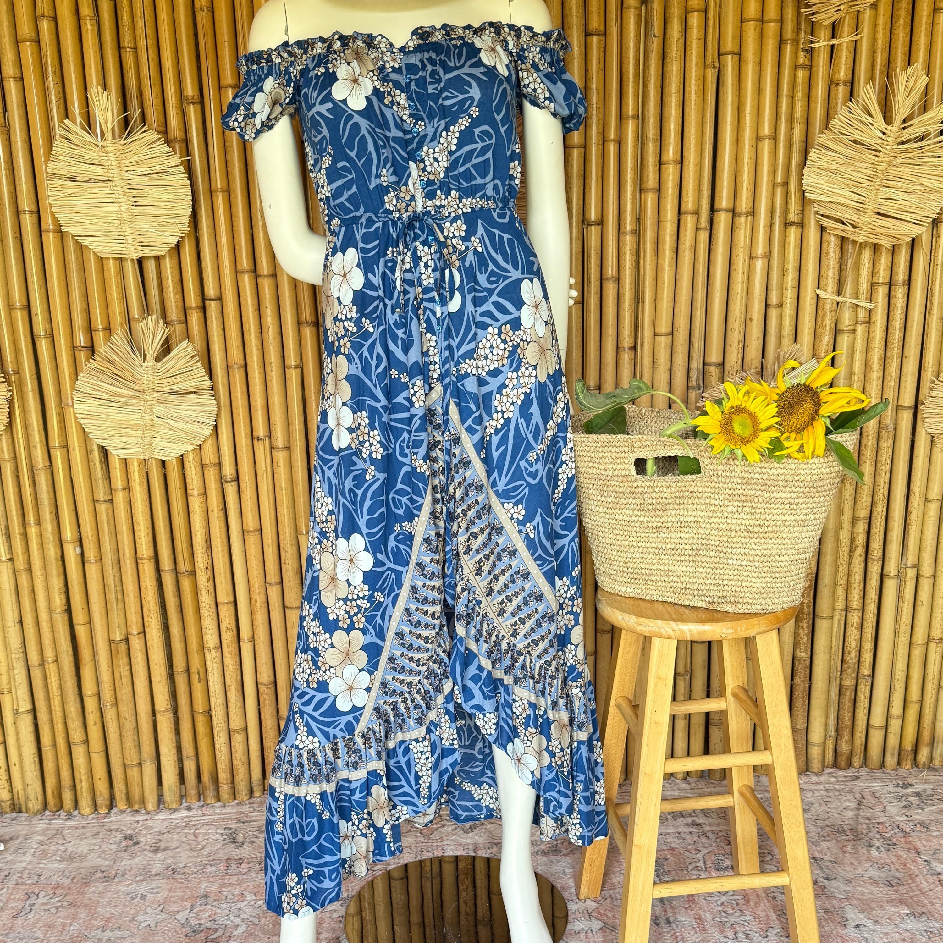 A mannequin wearing a blue floral print dress stands next to a woven basket filled with yellow flowers, placed on a wooden stool against a bamboo wall.