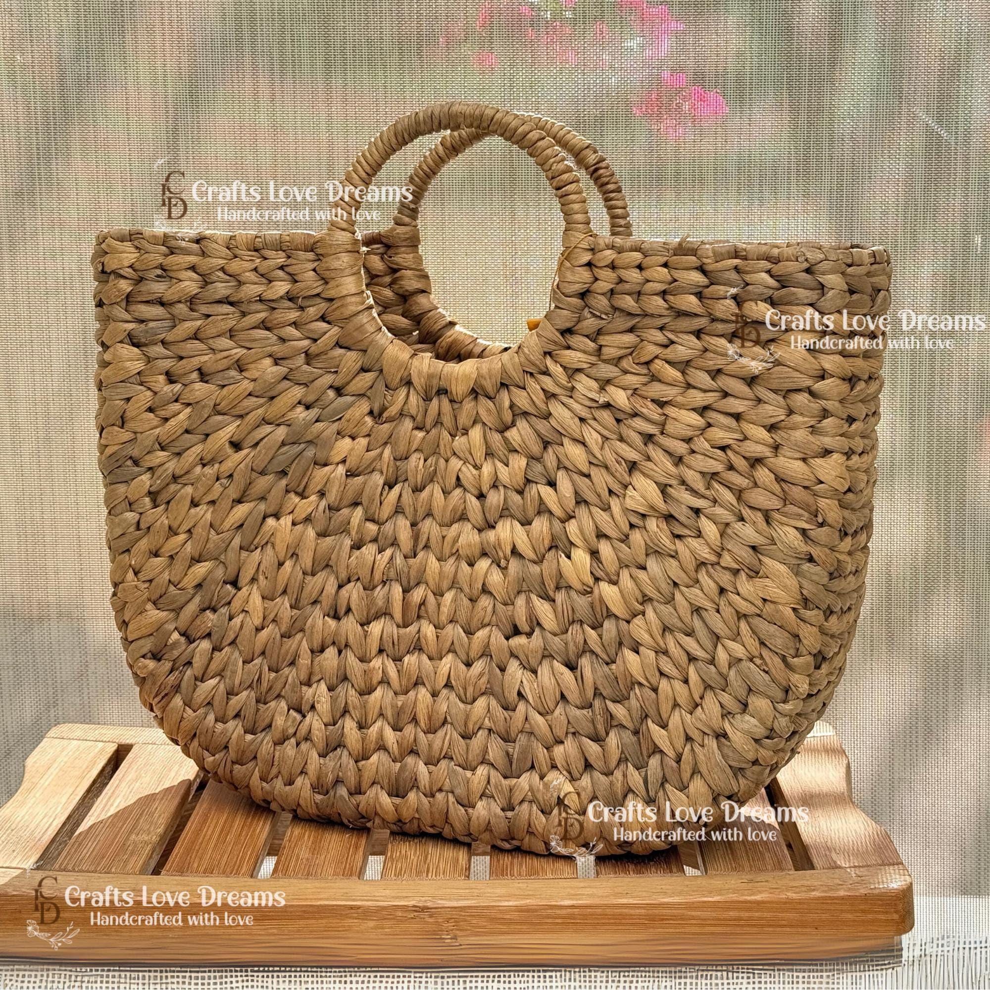 A woven handbag with a round handle, displayed on a wooden surface.