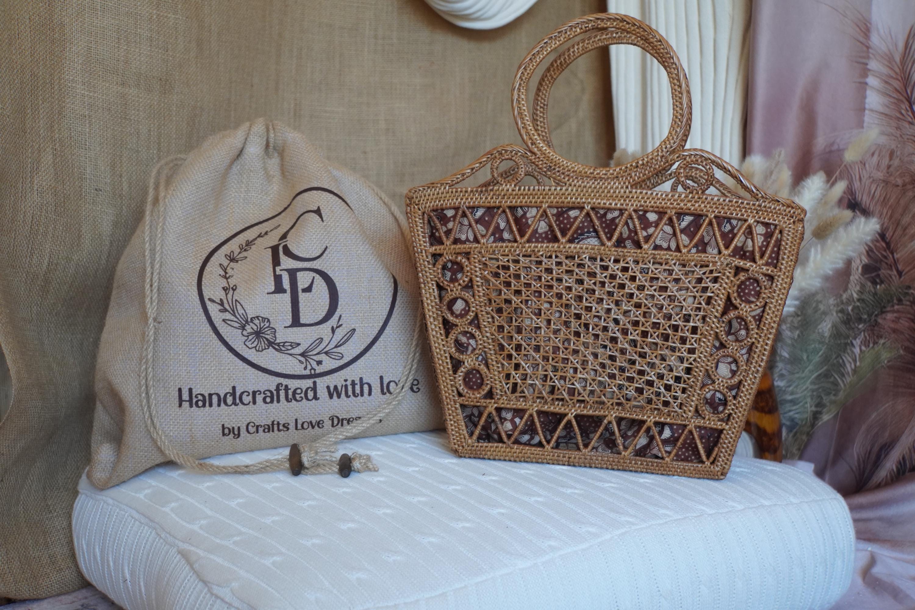 a handcrafted woven bag and a woven purse placed on a white cushion.