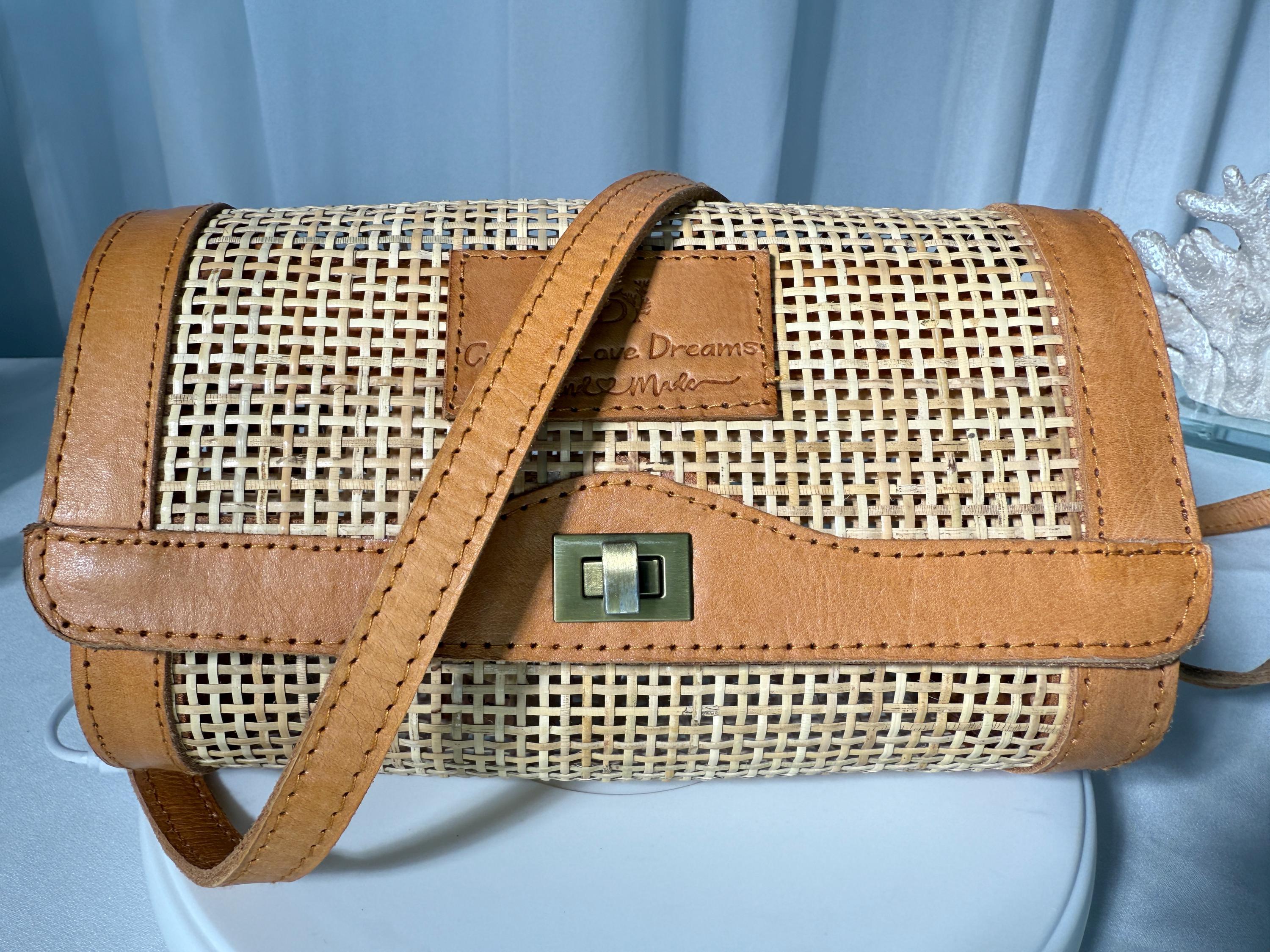 A brown woven purse with a metal clasp and leather trim, featuring a textured pattern.