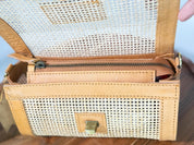 a tan-colored handbag with a woven texture, featuring a zipper closure and a small metal clasp.
