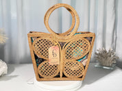 A handbag with a butterfly-shaped design, featuring a woven pattern and a handle.