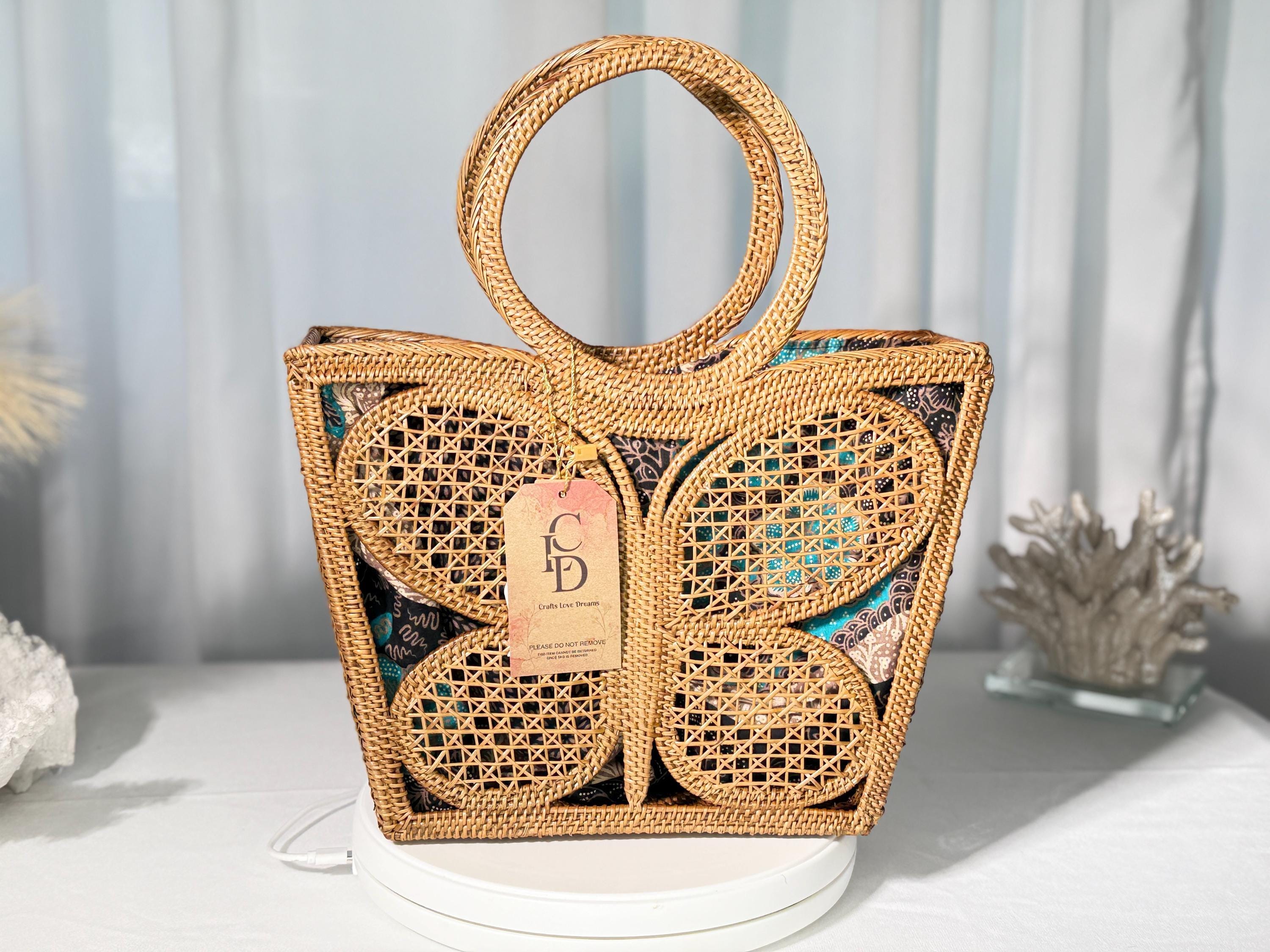 A handbag with a butterfly-shaped design, featuring a woven pattern and a handle.