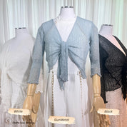 Two mannequins wearing the sheer knit cardigan shrug in GunMetal and Black over white outfits